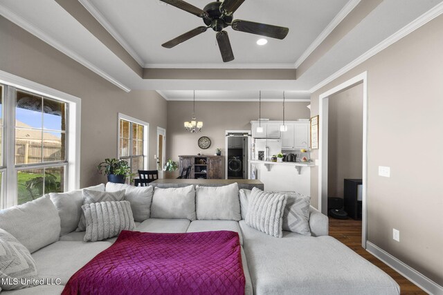 169 Beechwood Cir, Pearl, MS 39208 - living area with dark wood-style flooring, a chandelier, a tray ceiling, a ceiling fan, and crown molding