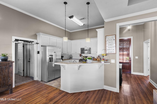 169 Beechwood Cir, Pearl, MS 39208 - kitchen with stainless steel appliances, a peninsula, dark wood-type flooring, a breakfast bar, and hanging light fixtures