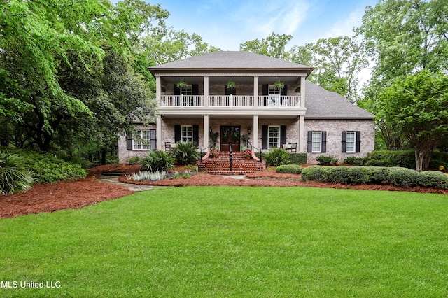 view of front of property featuring a front lawn, covered porch, and a balcony