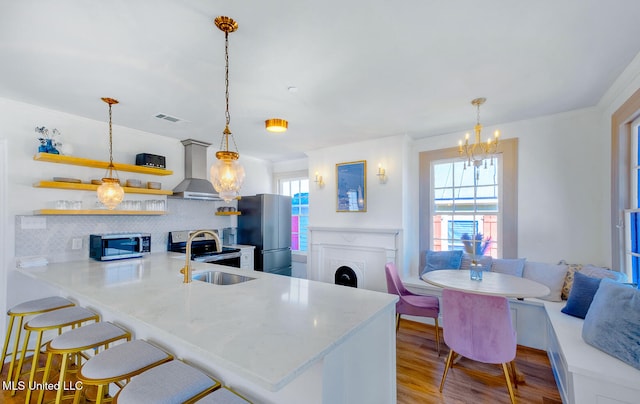 kitchen featuring kitchen peninsula, stainless steel appliances, light hardwood / wood-style flooring, and a healthy amount of sunlight