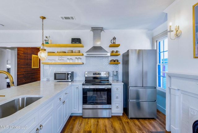 kitchen with sink, appliances with stainless steel finishes, dark hardwood / wood-style flooring, white cabinetry, and extractor fan