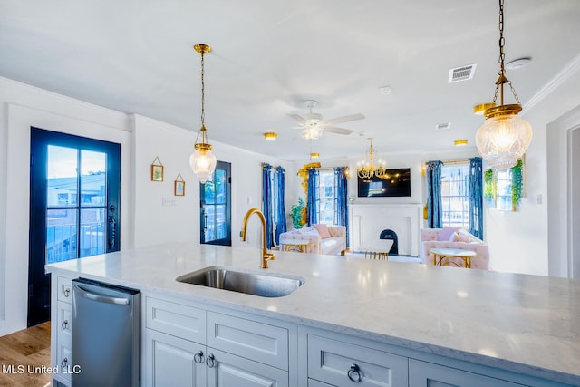 kitchen featuring pendant lighting, ornamental molding, sink, and a wealth of natural light