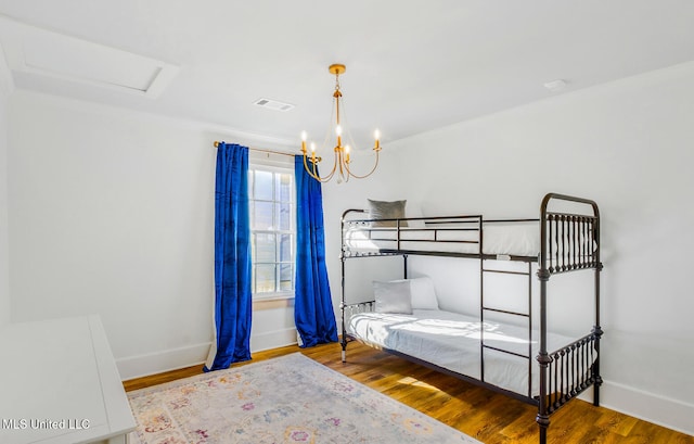 bedroom with a notable chandelier and hardwood / wood-style flooring