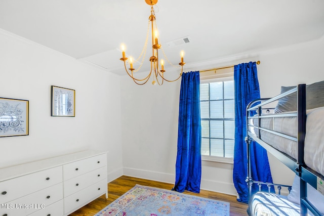 bedroom with ornamental molding, dark wood-type flooring, and an inviting chandelier