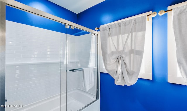 bathroom featuring bath / shower combo with glass door