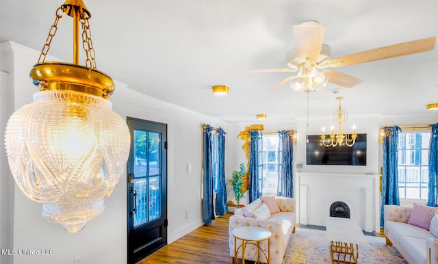 living room with ceiling fan, wood-type flooring, and crown molding