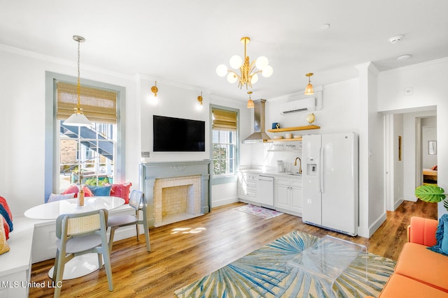 living room featuring crown molding, plenty of natural light, light hardwood / wood-style floors, and a wall mounted air conditioner