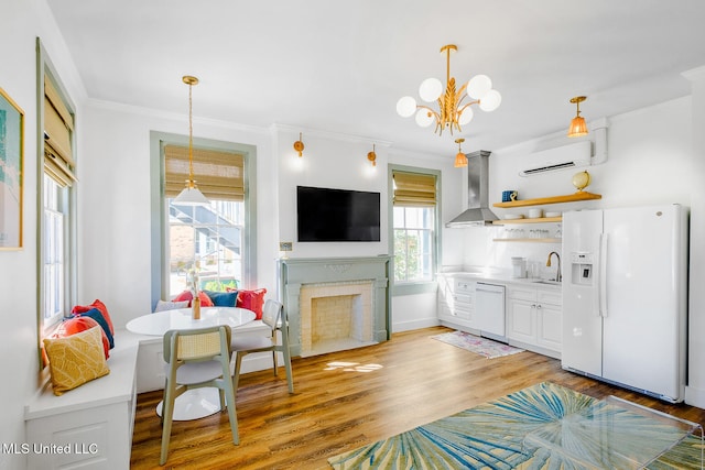 interior space with sink, an inviting chandelier, a wall mounted AC, light hardwood / wood-style floors, and ornamental molding