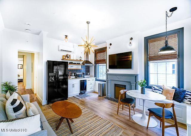 living room featuring light wood-type flooring and a wall unit AC