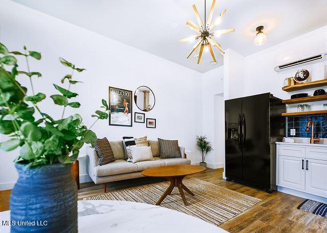 living room with dark hardwood / wood-style floors and an inviting chandelier