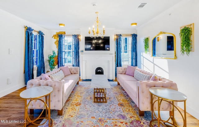 living room featuring a chandelier, light wood-type flooring, and ornamental molding