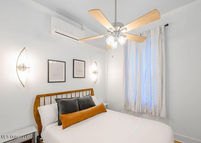 bedroom with a wall mounted AC and ceiling fan