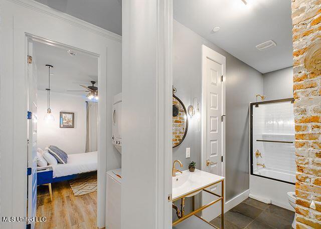 bathroom with ceiling fan, shower / bathing tub combination, wood-type flooring, and ornamental molding