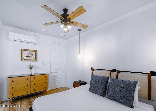 bedroom featuring a wall mounted AC, ceiling fan, dark wood-type flooring, and ornamental molding