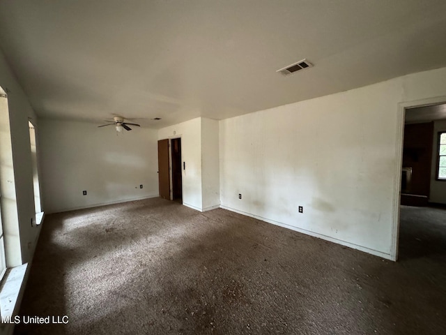 empty room featuring dark carpet and ceiling fan