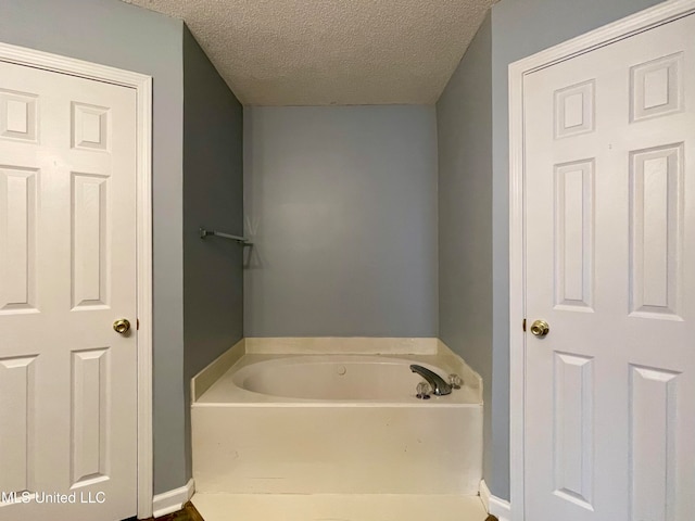 bathroom with a textured ceiling and a bathing tub