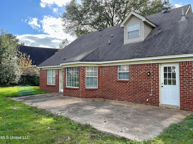 rear view of property with a yard and a patio