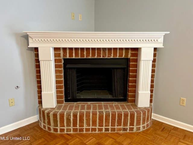 interior details featuring parquet flooring and a brick fireplace