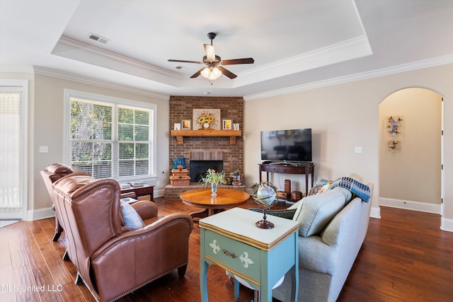 living room featuring a tray ceiling and dark hardwood / wood-style flooring