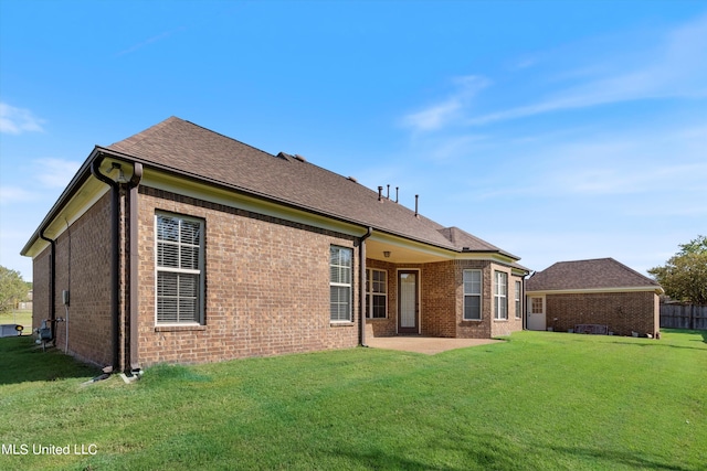 rear view of house with a yard and a patio