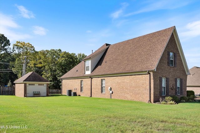 rear view of property featuring central AC and a lawn