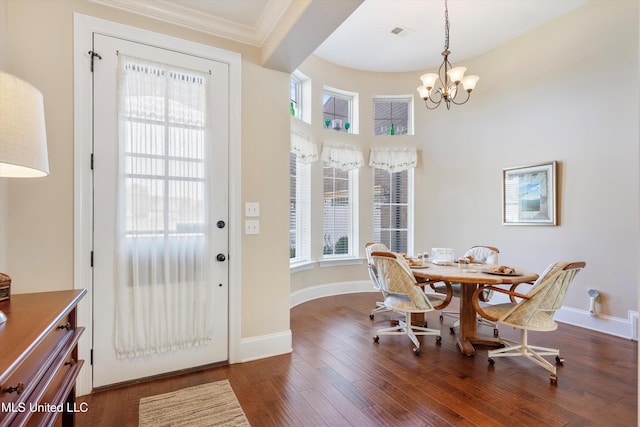 dining room featuring crown molding, dark hardwood / wood-style flooring, and a chandelier