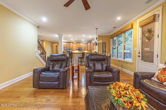 living room featuring ceiling fan with notable chandelier, light hardwood / wood-style floors, decorative columns, and ornamental molding