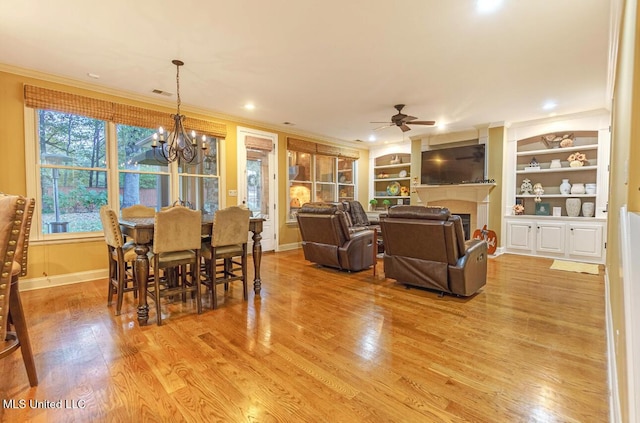 4655 Bonne Terre Dr, Nesbit, MS 38651 - dining area featuring crown molding, light wood-style floors, a ceiling fan, a chandelier, and built in shelves