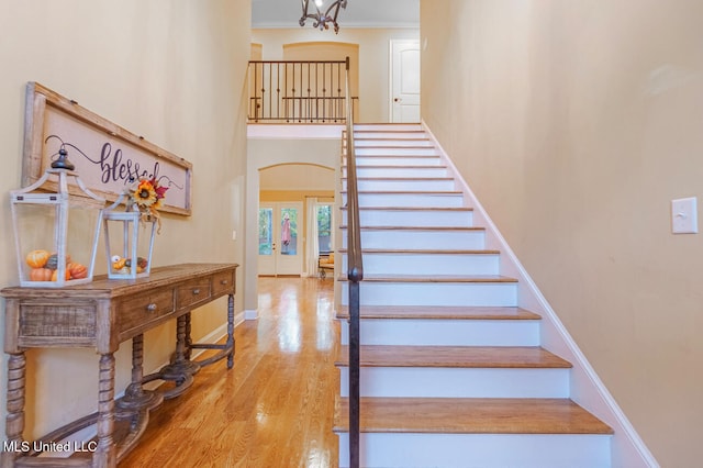 stairs with wood-type flooring, french doors, and crown molding