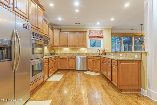 kitchen with light wood-type flooring, crown molding, and appliances with stainless steel finishes