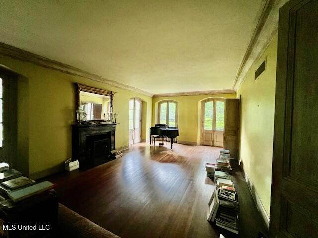 living area featuring ornamental molding, wood finished floors, and a fireplace