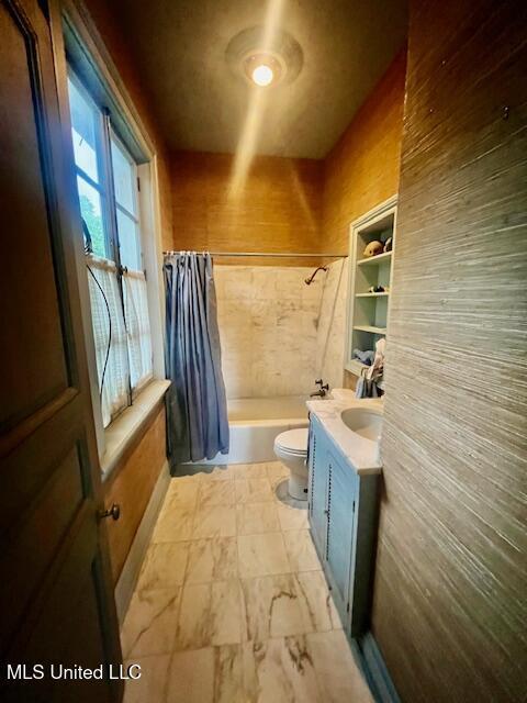 full bath featuring shower / bath combo with shower curtain, toilet, and vanity