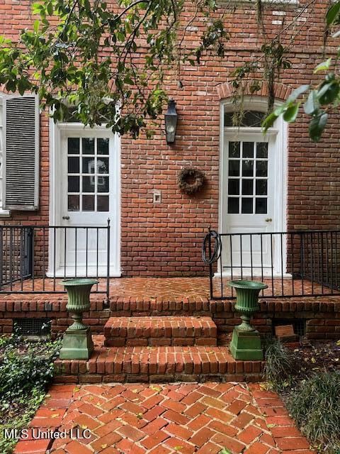 view of exterior entry with brick siding