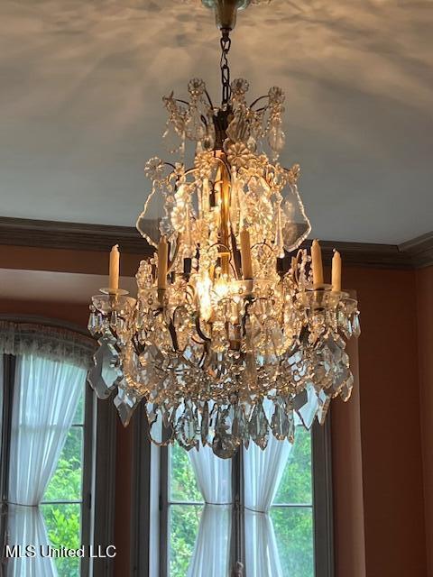 details with an inviting chandelier and crown molding