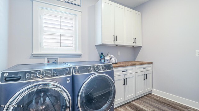 washroom featuring washing machine and dryer, dark hardwood / wood-style flooring, and cabinets