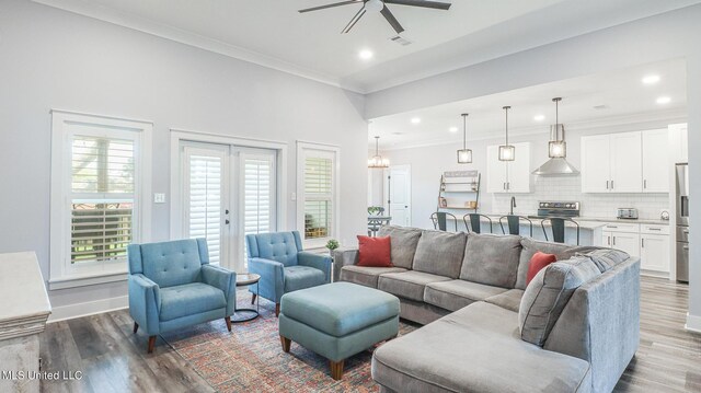 living room with crown molding, dark hardwood / wood-style floors, french doors, and ceiling fan