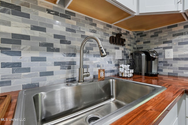 123A Lakeside Villa Dr Unit C, Diamondhead, MS 39525 - details with white cabinetry, a sink, wood counters, and decorative backsplash