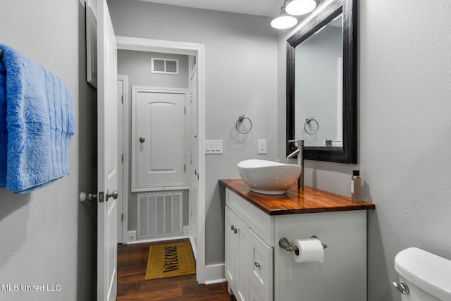 123A Lakeside Villa Dr Unit C, Diamondhead, MS 39525 - half bath featuring visible vents, toilet, vanity, and wood finished floors