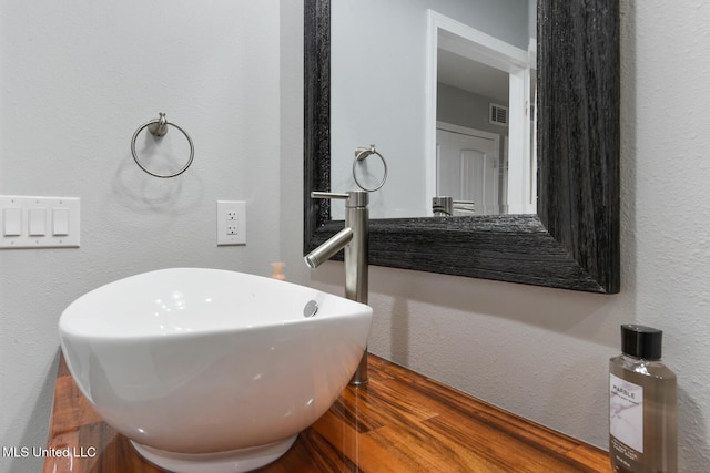 123A Lakeside Villa Dr Unit C, Diamondhead, MS 39525 - bathroom featuring a sink, visible vents, a textured wall, and wood finished floors