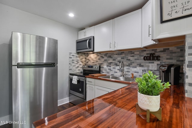 123A Lakeside Villa Dr Unit C, Diamondhead, MS 39525 - kitchen featuring backsplash, a sink, white cabinetry, butcher block countertops, and stainless steel appliances