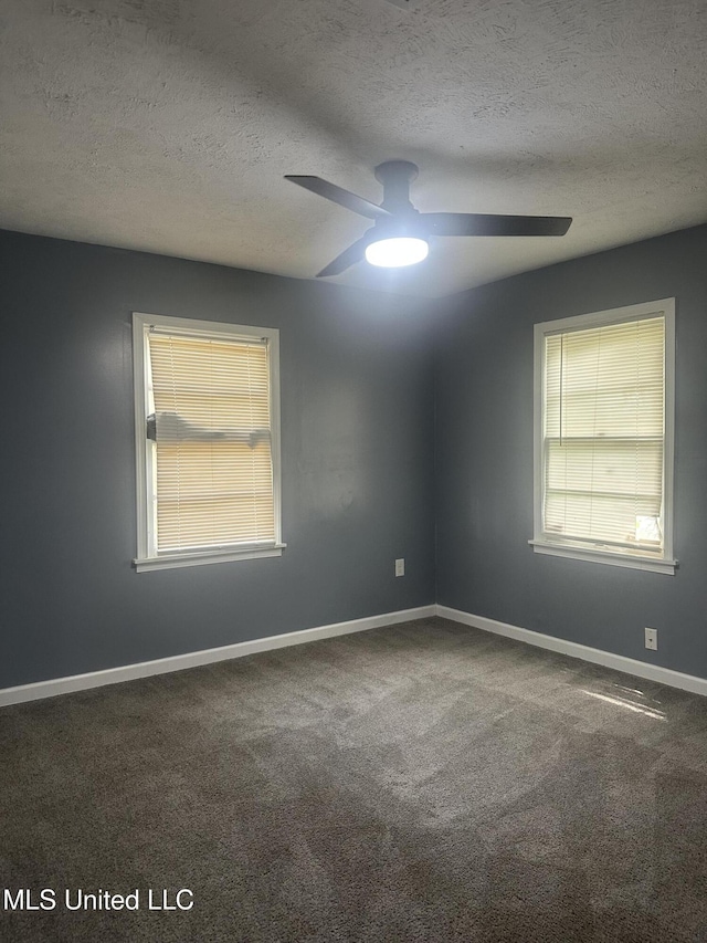 carpeted spare room with baseboards, a textured ceiling, a healthy amount of sunlight, and ceiling fan