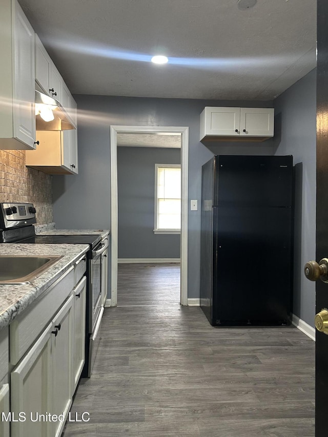 kitchen with freestanding refrigerator, baseboards, white cabinets, stainless steel electric stove, and tasteful backsplash