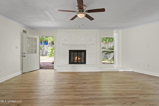 122 Carroll Ave, Long Beach, MS 39560 - unfurnished living room with wood finished floors, a ceiling fan, crown molding, and a brick fireplace