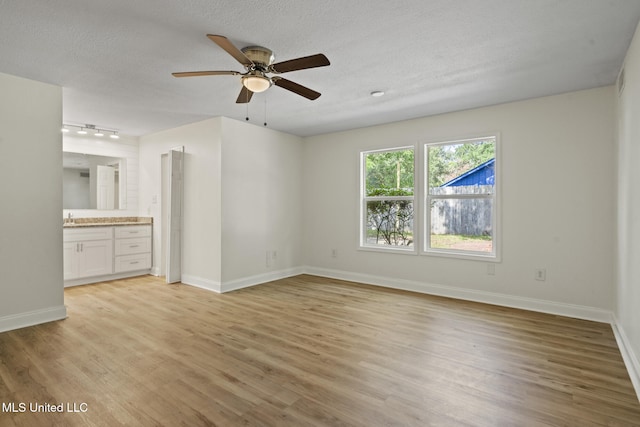 122 Carroll Ave, Long Beach, MS 39560 - unfurnished bedroom with light wood-style flooring, ensuite bath, a textured ceiling, and ceiling fan