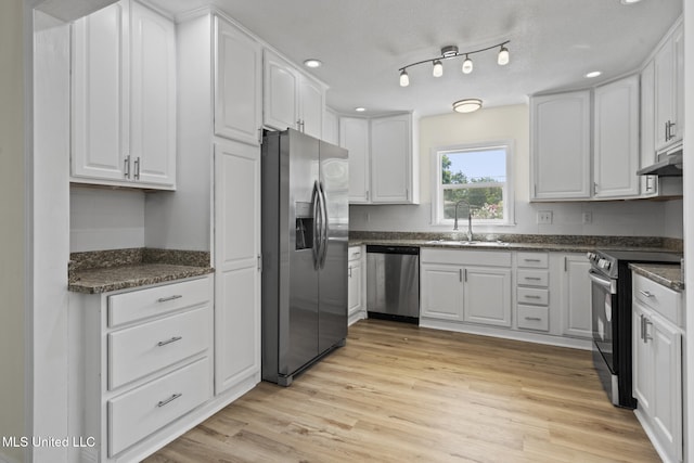 122 Carroll Ave, Long Beach, MS 39560 - kitchen with stainless steel appliances, white cabinetry, light wood-style floors, and dark stone counters
