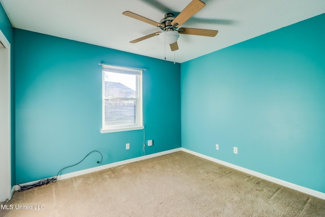 carpeted spare room with ceiling fan