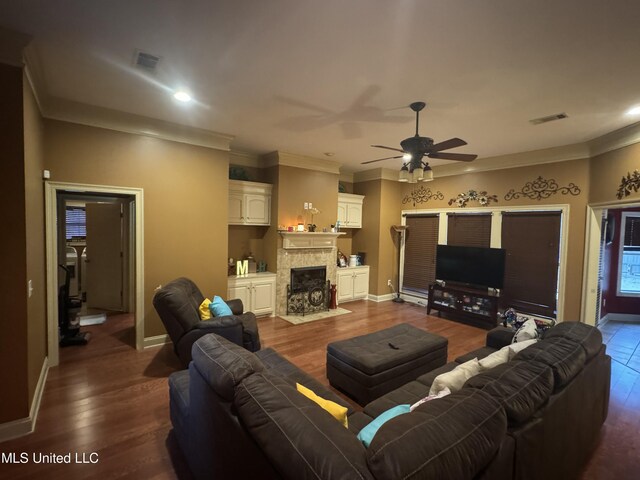 living room featuring ceiling fan, a fireplace, dark wood-type flooring, and ornamental molding