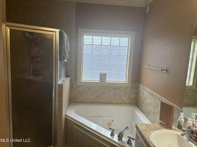 bathroom featuring vanity, plus walk in shower, crown molding, and a wealth of natural light