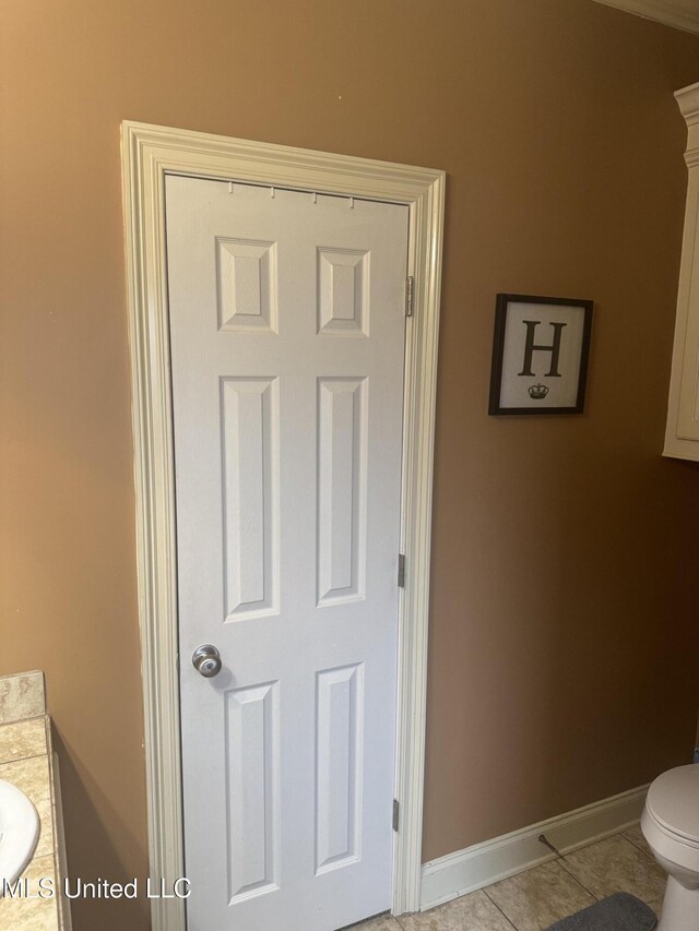 bathroom with tile patterned flooring, vanity, and toilet