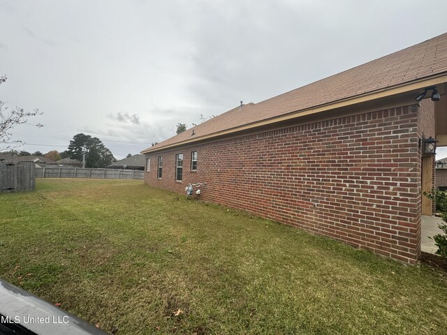 view of side of home with a yard